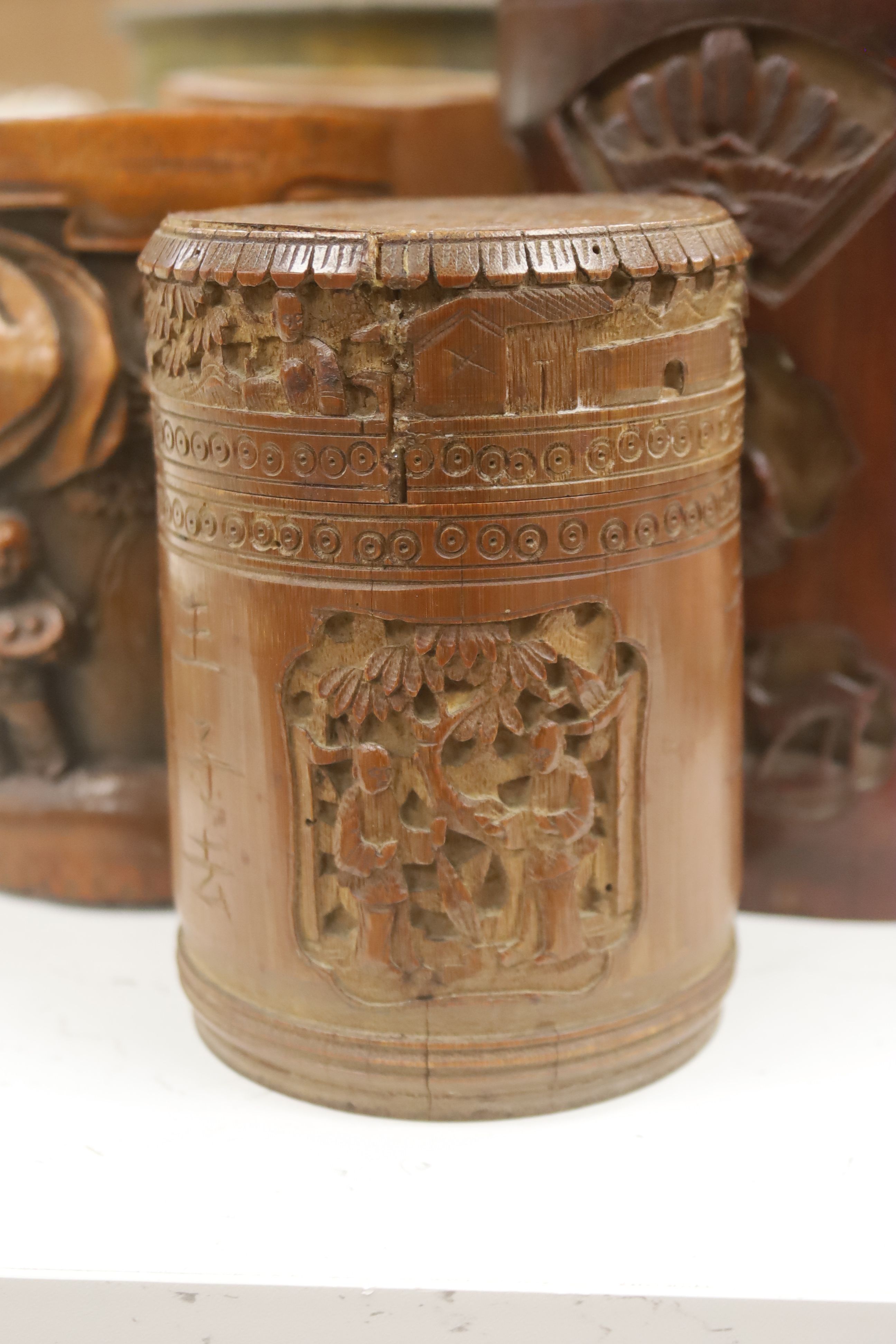 Six 19th/20th century Chinese carved brush pots and a similar carved tea caddy, tallest 20cm